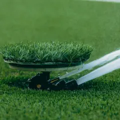 Zraszacze wynurzalne na boisku sportowym, jeden z rodzajów zraszaczy wynurzalnych, nawadnia zieloną murawę.