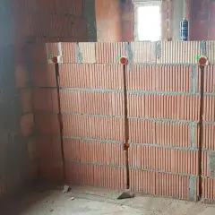 Wykonano bruzdy pod kable w ścianie z pustaków ceramicznych. Widoczne są puszki instalacyjne.