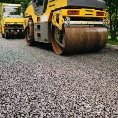 Walec drogowy wykonuje zagęszczanie piasku na nowej nawierzchni.