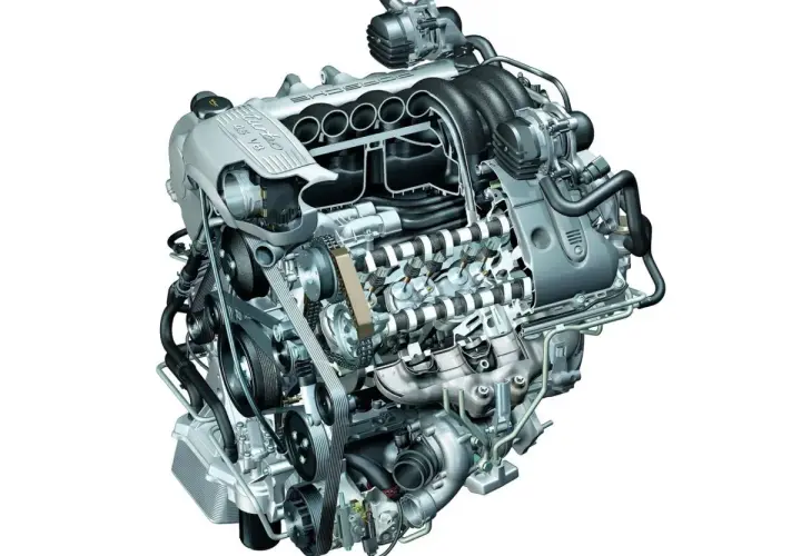 Silnik V8 turbo z widocznym układem dolotowym i pasami napędowymi. To serce potężnego samochodu, gotowe do pracy.