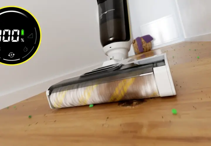 Odkurzacz Karcher z obrotową szczotką zbiera zielone kuleczki i brud z drewnianej podłogi. Wyświetlacz pokazuje 100% baterii.