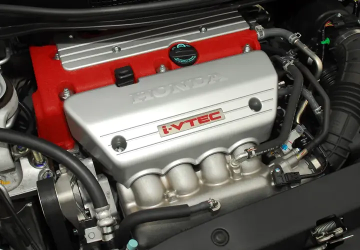 Silnik Honda z technologią i-VTEC. Czerwona pokrywa zaworów i srebrna osłona z napisem HONDA.