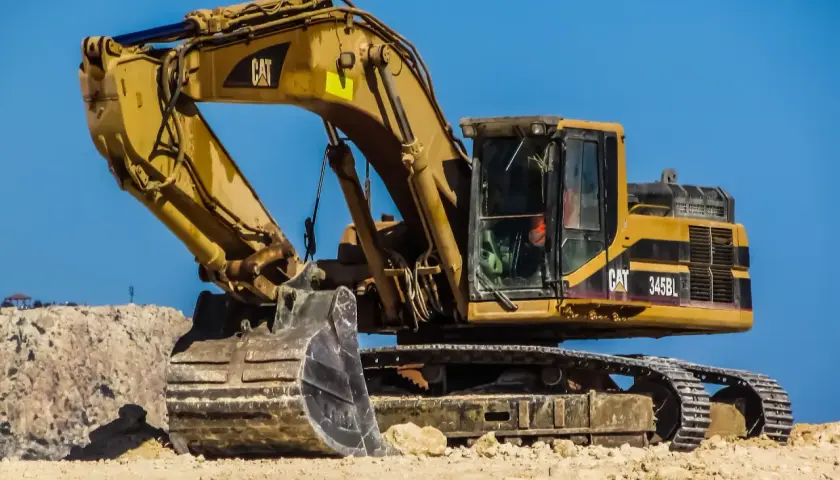 Żółta koparka przedsiębierna CAT 345BL na budowie, gotowa do pracy.