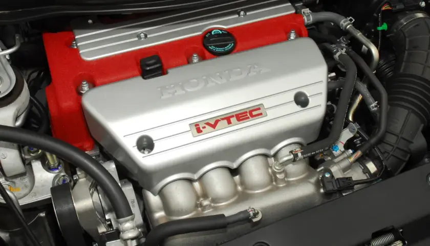 Silnik Honda z technologią i-VTEC. Czerwona pokrywa zaworów i srebrna osłona z napisem HONDA.