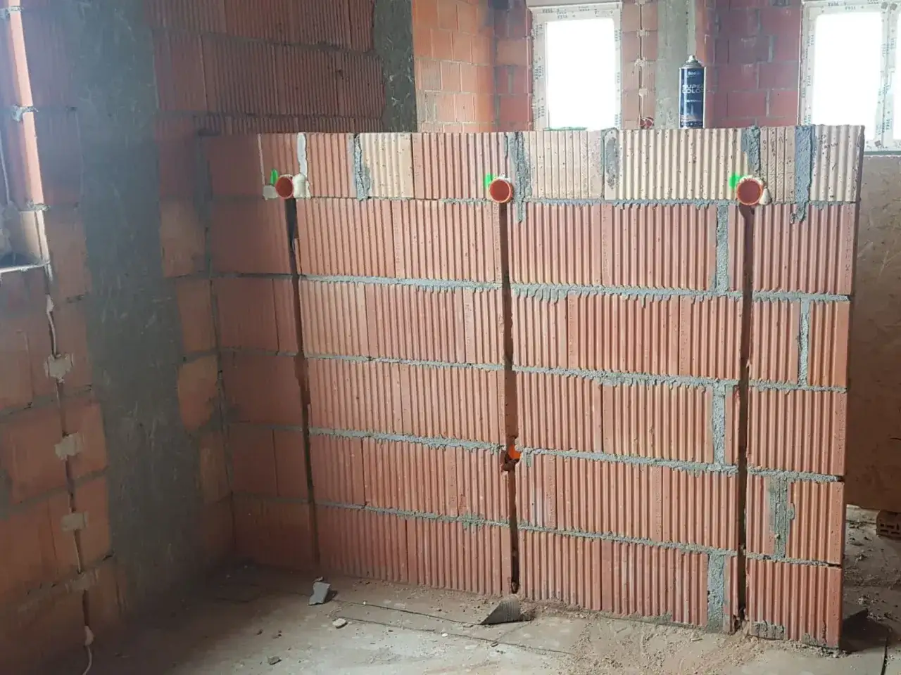 Ściana z pustaków ceramicznych z wyżłobieniami pod kable i puszkami instalacyjnymi.