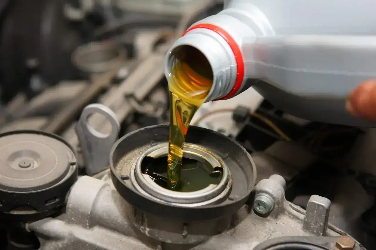 Wlewanie oleju do silnika Hatz Diesel. Płynna złota maź zasila serce maszyny.